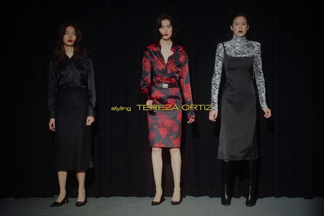 Video Reference: Clothing, Fashion, Dress, Fashion design, Outerwear, Coat, Event, Performance, Trench coat, Person, Standing, Posing, Woman, People, Photo, Man, Front, Holding, Young, Group, Wearing, Girl, Room, Court, Umbrella, Sign, White, Shirt, Skirt, Day dress, Footwear, Carpet, Fashion model, One-piece garment, Cocktail dress, Mantle, Costume design, Handbag, Miniskirt, Premiere, High heels, Red carpet, Little black dress, Sheath dress