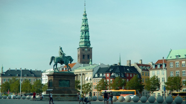 Video Reference: Landmark, Spire, Steeple, Tower, Building, Architecture, City, Monument, Sky, Tourist attraction, Outdoor, Road, Street, Boat, Large, Man, People, Traffic, Sign, Walking, Water, Driving, View, Church, Stop, Truck, Group, White, Riding, Intersection, Light, Standing, Parked, Red, Motorcycle, Tall, Statue, Horse, Sculpture