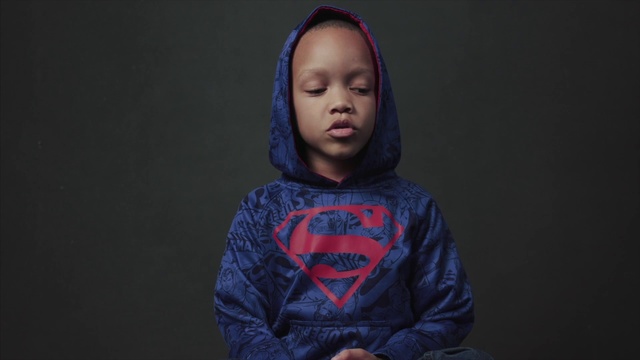 Video Reference: Face, Blue, Head, Cheek, Outerwear, Hoodie, Hairstyle, Chin, Sitting, Forehead