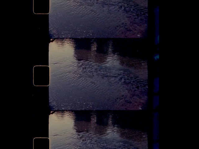 Video Reference: Blue, Water, Black, Purple, Reflection, Light, Sky, Darkness, Architecture, Line, Outdoor, Lake, Sitting, Dark, Body, Street, Traffic, Boat, River, Floating, Dock, Standing, Large, Sunset, Walking, Parked, Sign, Bridge, White, Man, Rain, Text