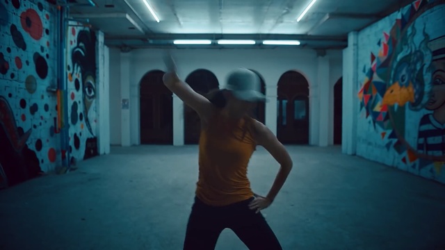 Video Reference: Blue, Light, Arm, Room, Human body, Leg, Muscle, Photography, Physical fitness, Dance, Person, Indoor, Man, Young, Holding, Standing, Shirt, Woman, Doing, Riding, Board, Wearing, Game, Playing, Air, Ball, Ramp