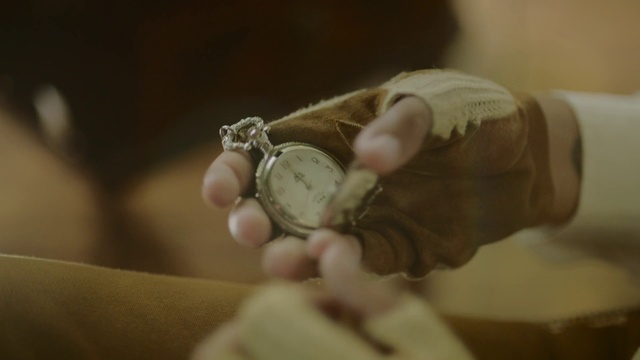 Video Reference: Hand, Watch, Wrist, Fashion accessory, Finger, Jewellery, Indoor, Thing, Person, Sitting, Holding, Small, Looking, Front, Piece, Clock, Table, Woman, Wearing, White, Cat, Man, Bed, Device