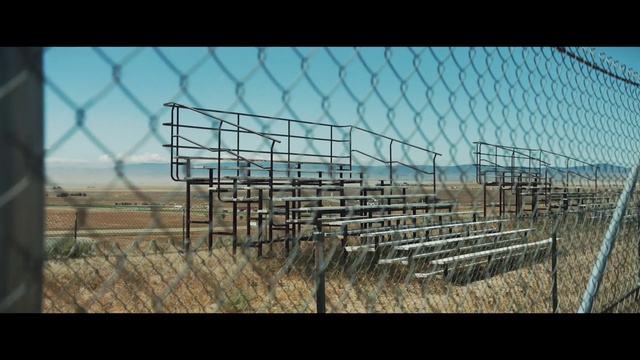 Video Reference: sky, wire fencing, field, structure, fence, grass, grass family, rural area, prairie, biome
