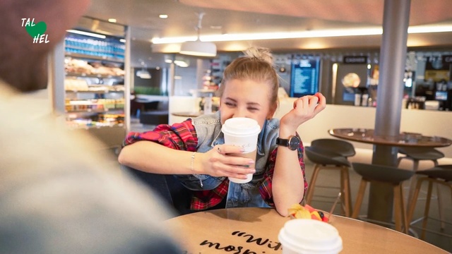 Video Reference: Restaurant, Dairy, Person, Indoor, Table, Food, Cup, Young, Front, Sitting, Coffee, Kitchen, Eating, Boy, Plate, Drinking, Holding, Cake, Small, Little, Man, Standing, Shirt, Woman, Pizza, White, Fast food, Text, Clothing, Human face, Tableware