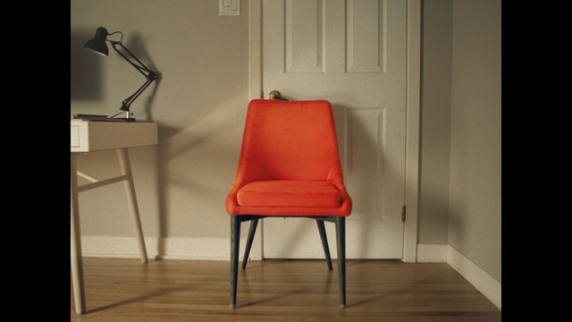 Video Reference: Chair, Furniture, Red, Orange, Room, Material property, Interior design, Table, Floor, Still life photography, Person