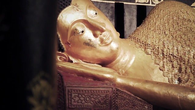 Video Reference: statue, effigy, golden, reclining, ornate, carved, close-up, museum, religious, artifact, sculpture, indoor, traditional, decorative