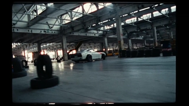 Video Reference: Luxury vehicle, Vehicle, Building, Hangar, Automotive design, Car, Parking lot, Factory, Auto part, Wheel, Person