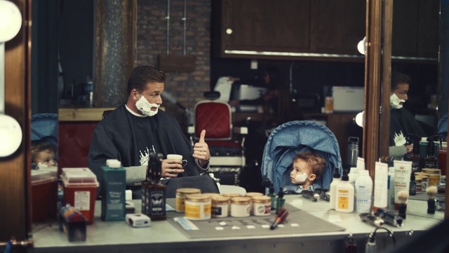 Video Reference: Man, Children, Boy, Barber, Barbershop, Mirror, Reflection , Person, Table, Indoor, Sitting, Food, Coffee, Window, Front, Restaurant, Drinking, Woman, Eating, People, Kitchen, Glass, Room, Holding, Living, Group, Standing, Plate, Human face, Clothing, Bottle, Text