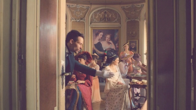 Video Reference: Art, Room, Painting, Visual arts, Person, Indoor, Cabinet, Window, Sitting, Man, Girl, Small, Little, Open, Front, Mirror, Woman, Standing, Young, Door, Holding, Refrigerator, Kitchen, Clothing, Human face, Wedding