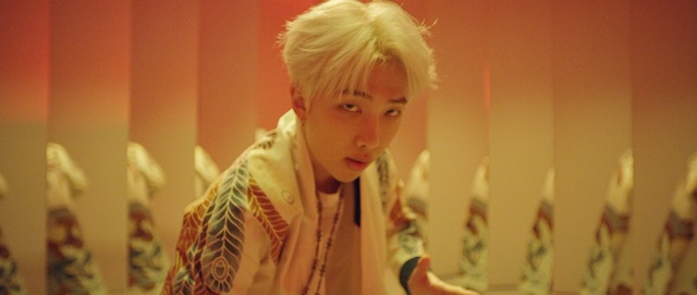 Video Reference: Blond, Person, Indoor, Woman, Mirror, Looking, Front, Man, Standing, Teeth, Wearing, Shirt, Holding, Cake, Young, Table, Hair, Kitchen, Food, Birthday, Brushing, White, Sink, Pink, Phone, Room, Human face, Wall, Clothing, Portrait