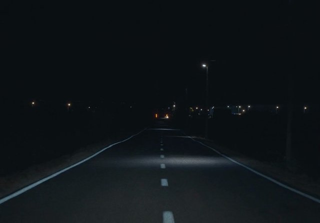 Video Reference: night, road, empty road, highway, streetlights, darkness, driving, lane markings, perspective, outdoors, travel, traffic, asphalt