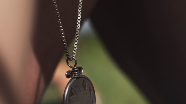 Video Reference: jewellery, necklace, fashion accessory, pendant, locket, close up, chain, macro photography, Person