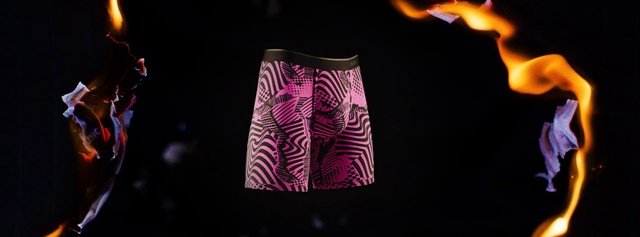 Video Reference: Lampshade, Light, Lighting, Lighting accessory, Pink, Shorts, Magenta, Trunks, Sportswear, Fire, Person, Indoor, Table, Nature, Fireplace, Man, Front, Dark, Standing, Sitting, Looking, Lit, Black, Woman, Cake, Shirt, Wearing, Glass, Holding, Young, Food, Soft drink