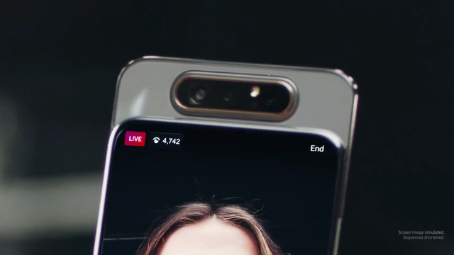 Video Reference: Gadget, Technology, Smartphone, Mobile phone, Electronic device, Iphone, Portable communications device, Material property, Feature phone, Communication device, Person, Cellphone, Phone, Camera, Looking, Woman, Holding, Front, Photo, Black, Hand, Mirror, Wearing, Close, Glasses, Young, Man, Standing, Car, Screenshot, Human face, Automotive