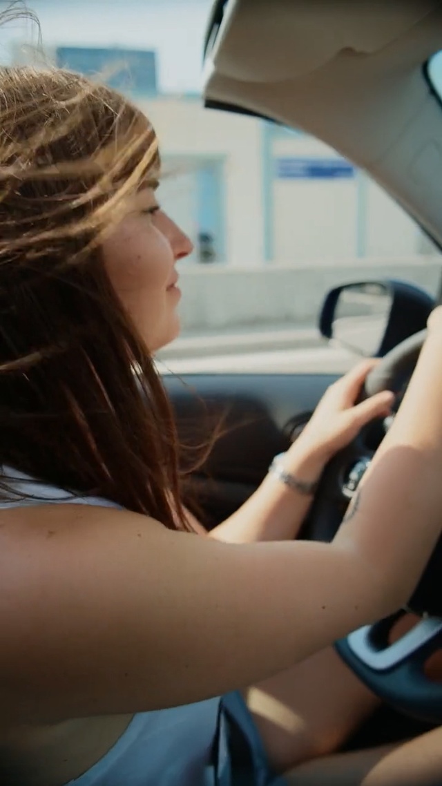 Video Reference: Hair, Driving, Steering wheel, Blond, Vehicle, Automotive design, Car, Auto part, Hand, Steering part