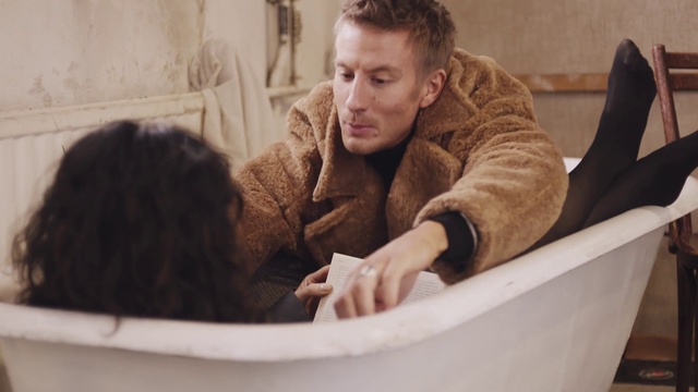 Video Reference: Bathtub, Person, Indoor, Sitting, Basket, Thing, Looking, Young, Table, Man, Woman, Child, Front, Boy, Sink, Brown, Girl, Black, Little, Laptop, White, Cat, Holding, Seat, Large, Tub, Water, Kitchen, Wall, Human face, Clothing