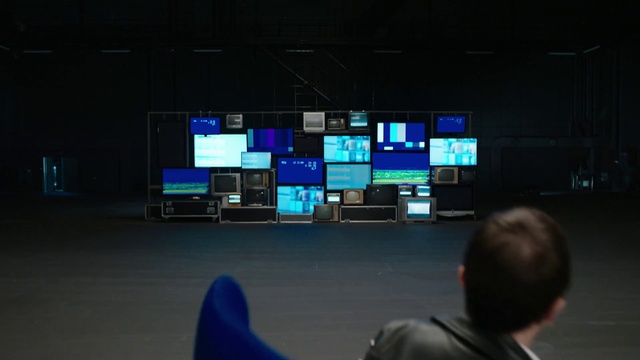 Video Reference: Broadcasting, Technology, Multimedia, Display device, Electronic device, Architecture, Media, Projection screen, Person, Indoor, Man, Airport, Television, Monitor, Room, Sitting, Front, Playing, Young, Video, Screen, Looking, Watching, Boy, Standing, Luggage, Game, Large, Woman, Computer, Table, People, Holding, Group, Living, Suitcase, Wii, Remote, Computer monitor, Ceiling, Laptop