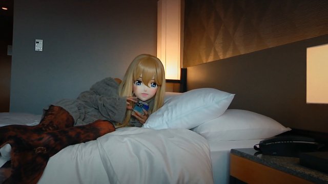 Video Reference: bed, hotel room, person, mask, anime mask, smartphone, indoor, relaxing, pillow, blanket, night, selfie, costume, lounge