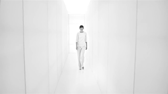 Video Reference: White, Standing, Fashion, Wall, Fashion design, Black-and-white, Photography, Outerwear, Room, Beige