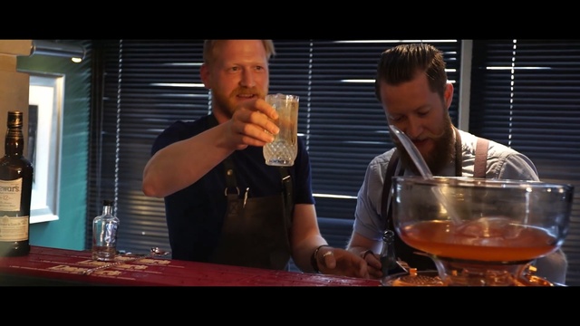 Video Reference: drink, alcoholic beverage, alcohol, liqueur, stemware, distilled beverage, glass, wine glass, cuisine, bar, Person