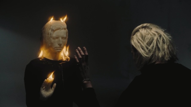 Video Reference: Lighting, Darkness, Sky, Photography, Fire, Performance, Night, Flame, Art, Person, Dark, Man, Looking, Front, Woman, Standing, Lit, Holding, Black, Glasses, Wearing, Table, Light, Young, Phone, Video, People, Playing, Statue, Human face, Candle