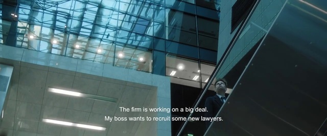 Video Reference: Architecture, Glass, Commercial building, Daylighting, Window film, Building, Facade, Window, Corporate headquarters, Metal, Indoor, Sitting, Large, Hand, Man, Holding, Standing, Room, Light, Table, Black, Mirror, Woman, Sign, Reflection, White, Tiled, Green, Playing, Player, Ball, Street, Red, Blue, Swinging, Tall, Clock, Court, Computer, People, Text