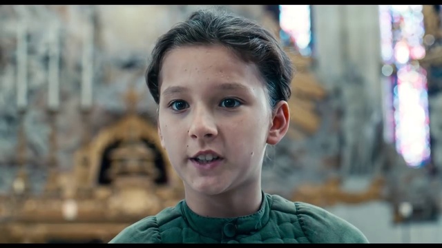 Video Reference: Face, Facial expression, Forehead, Chin, Head, Eyebrow, Cheek, Nose, Smile, Human, Person, Building, Young, Little, Front, Smiling, Boy, Holding, Table, Small, Sitting, Wearing, Standing, Shirt, Food, Green, Girl, Street, White, Plate, Pizza, Phone, Blue, City, Man, Human face, Child, Clothing, Portrait