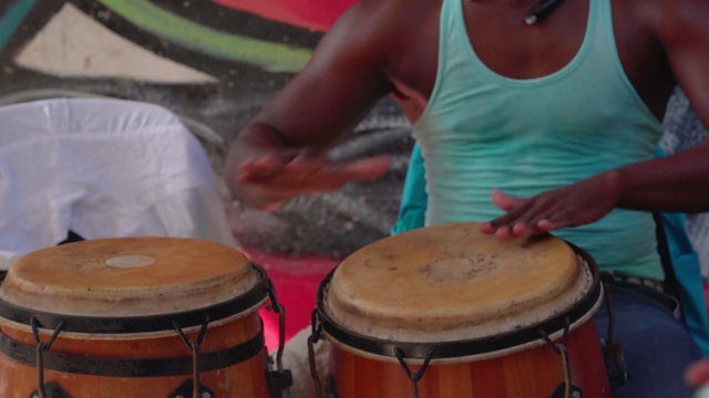 Video Reference: Drum, Musical instrument, Percussion, Atabaque, Membranophone, Bongo drum, Conga, Hand drum, Rebana, Percussionist, Person, Table, Woman, Cup, Coffee, Sitting, Front, Lady, Food, Cake, Girl, Holding, Young, Man, Plate, Eating, Standing, Large, Kitchen, Music, Drumhead, Idiophone, Djembe, Tom-tom drum, Drummer, Cymbal, Percussion mallet, Snare drum, Drum stick