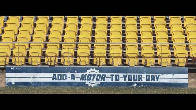 Video Reference: Font, Yellow, Text, Automotive exterior, Sport venue, Stadium, Vehicle registration plate, Symmetry, Pattern, Metal