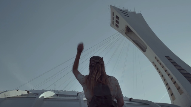 Video Reference: sky, vehicle, building, fixed link, wing, roof, Person