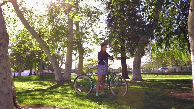 Video Reference: land vehicle, tree, plant, woody plant, bicycle, leisure, path, vehicle, recreation, grass, Person