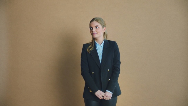 Video Reference: Suit, Clothing, Blazer, Outerwear, Standing, Formal wear, Jacket, Businessperson, Tuxedo, White-collar worker, Person