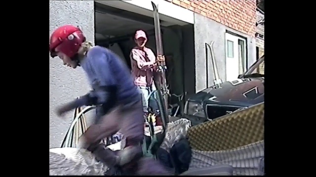 Video Reference: Snapshot, Mode of transport, Leg, Tree, Headgear, Helmet, Photography, Recreation, Window, Art, Person, Building, Man, Sitting, Holding, Riding, Young, Wearing, Woman, Suit, Hat, Street, Standing, Playing, Clothing, Music, Band, Musical instrument, Guitar