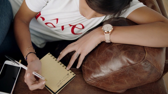 Video Reference: Hand, Arm, Leather, Leg, Fashion accessory, Beige, Wallet, Sitting, Wrist, Bag