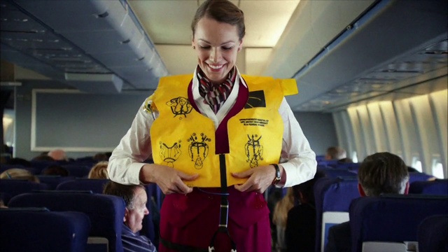 Video Reference: Yellow, Lifejacket, Flight attendant, Aerospace engineering, Airline, Air travel, Passenger, Uniform, Travel, Person