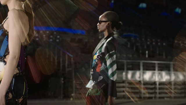 Video Reference: Snapshot, Fashion, Performance, Screenshot, Fun, Event, Photography, Performance art, Stage, Midnight, Person, Building, Woman, Man, Standing, Sitting, Table, Young, Holding, Wearing, Street, Girl, Walking, Riding, Room, Large, City, White, Doing, Phone, People, Air, Clothing, Concert, Human face, Crowd