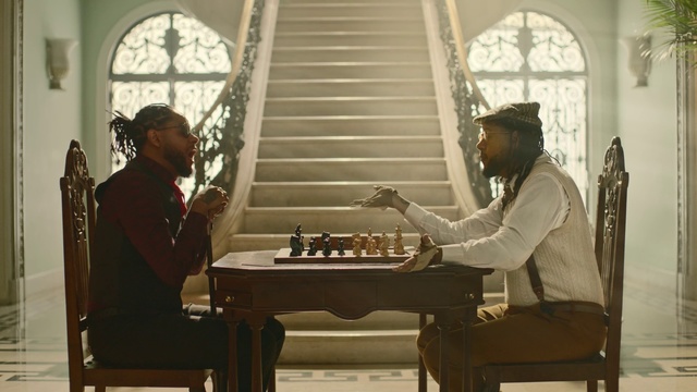 Video Reference: Games, Board game, Indoor games and sports, Chess, Recreation, Tabletop game, Folk instrument, Chessboard, Musical instrument, Furniture, Indoor, Person, Window, Table, Chair, Man, Woman, Front, Sitting, Mirror, Standing, Holding, Room, White, Piano, Wall, Dining table