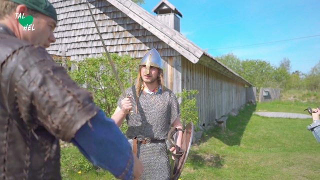 Video Reference: Grass, Recreation, Farm, Person, Outdoor, Holding, Man, Wearing, Standing, Building, Hat, Woman, Little, Sunglasses, Older, Green, Old, Carrying, Suit, Boy, Walking, Uniform, Young, Park, Sheep, Eating, Baseball, Red, Street, Field, White, Sky, Clothing, Plant, Fashion accessory, Sun hat