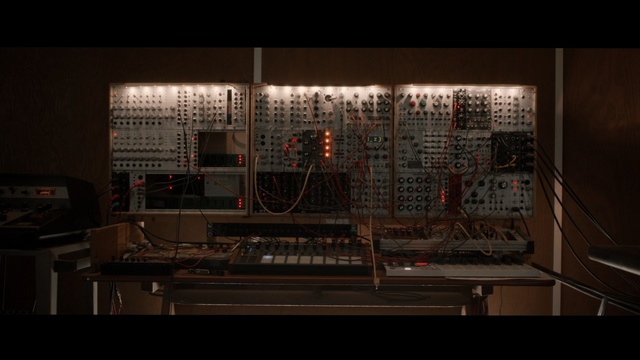 Video Reference: Darkness, Architecture, Font, Electronic instrument, Screenshot, Room, Furniture, Metal, Art, Person