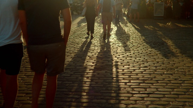 Video Reference: Cobblestone, Water, Shadow, Light, Morning, Sunlight, Flooring, Street, Leg, Road surface, Person, Outdoor, Building, Woman, Umbrella, Standing, Walking, People, Sidewalk, Holding, Rain, Man, Group, Wet, Young, Track, Brick, City, Train, Red, Ground, Clothing, Footwear, Way