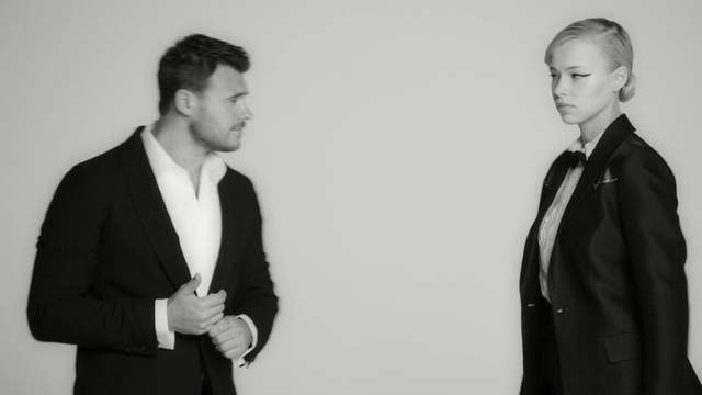 Video Reference: suit, black and white, gentleman, formal wear, photography, standing, fashion, outerwear, monochrome photography, white collar worker, Person