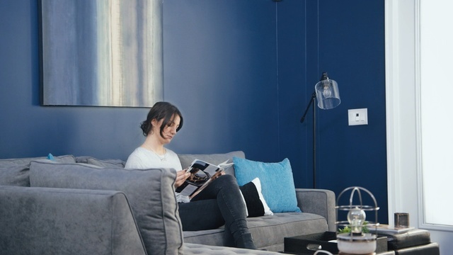 Video Reference: Blue, Room, Couch, Furniture, Comfort, Sitting, Interior design, Leg, Electronic device, Living room, Person