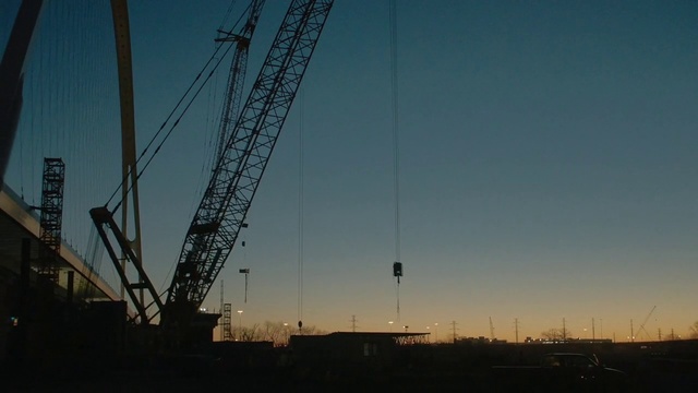 Video Reference: Sky, Overhead power line, Crane, Cloud, Line, Urban area, Evening, Electricity, Atmosphere, Public utility