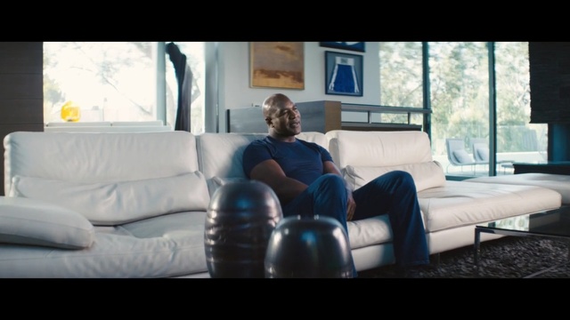 Video Reference: blue, furniture, couch, room, sitting, living room, interior design, home, angle, table, Person