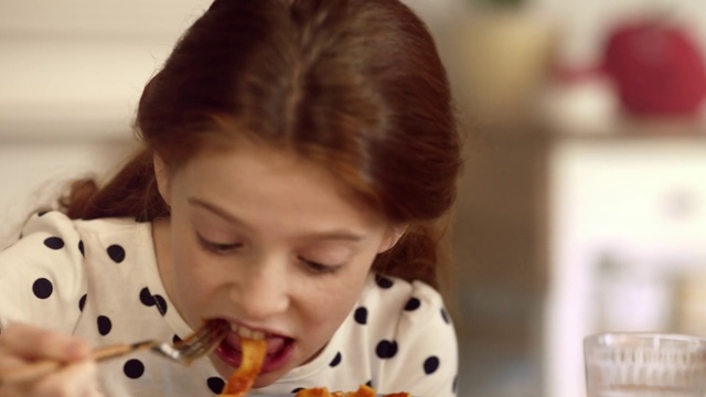 Video Reference: Hair, Child, Face, Nose, Head, Hairstyle, Eating, Lip, Baby, Brown hair, Person, Indoor, Food, Woman, Young, Little, Looking, Sitting, Front, Girl, Table, Small, Boy, Female, Wearing, Holding, Plate, Kitchen, Cake, Standing, Human face, Toddler, Portrait