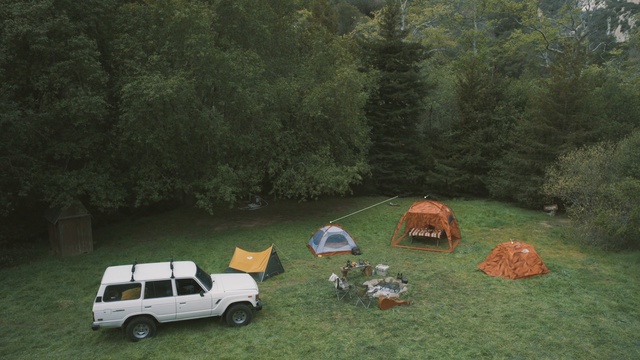 Video Reference: car, camping, wilderness, vehicle, grass, tree, plant, landscape, rural area, motor vehicle
