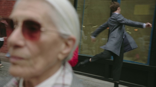 Video Reference: Lady, Fashion, Human, Pedestrian, Glasses, Street fashion, Photography, Eyewear, Ear, Street, Person, Indoor, Man, Holding, Woman, Looking, Standing, Young, Wearing, Smiling, Food, Girl, Table, Wine, Red, White, People, Room, Playing, Hat, Shirt, Clothing, Human face, Crowd