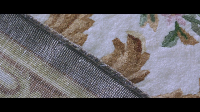 Video Reference: Leaf, Textile, Beige, Pattern, Linens, Table, Sitting, Small, Cake, Fabric, Food, Holding, Cut, Covered, Laying, Towel, Man, White, Rug, Cat, Colored