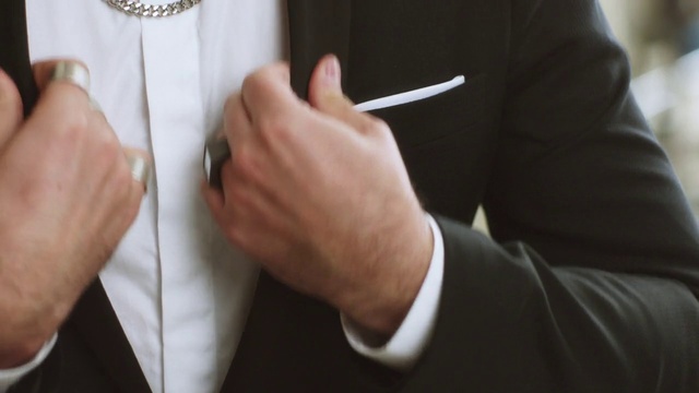 Video Reference: Hand, Finger, Suit, Ring, Formal wear, Gesture, Tuxedo, Wedding ring, Fashion accessory, Thumb, Person