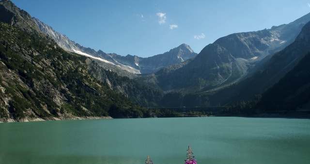 Video Reference: Mountainous landforms, Mountain, Body of water, Mountain range, Nature, Highland, Lake, Sky, Glacial lake, Fjord, Outdoor, Water, Sitting, Background, Front, View, Large, Side, Overlooking, Green, Standing, Bench, Boat, White, Red, Snow, River, Hill, Man, Tall, Cloud, Landscape, Surrounded